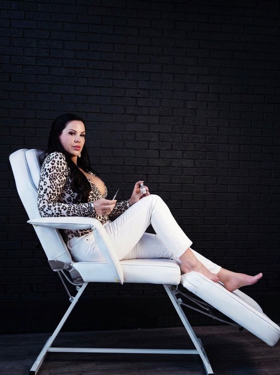 Chelsea Walker, nurse injector, seated in the Advanced Aesthetics studio against a black brick wall